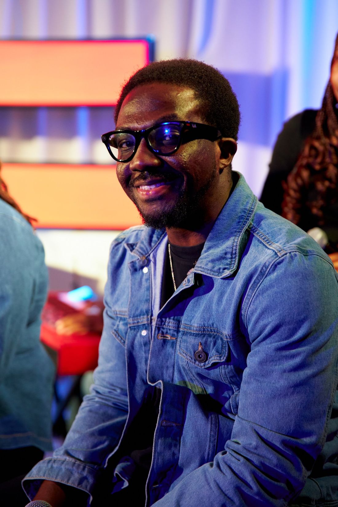 Press photo: smiling in glasses and a blue denim jacket