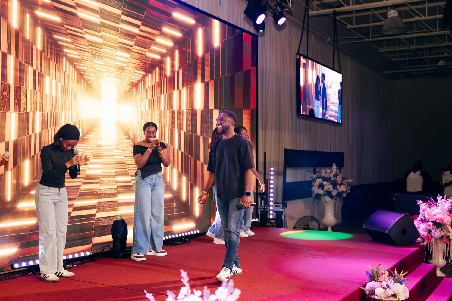 Divine laughing with fellow singers on a lit stage
